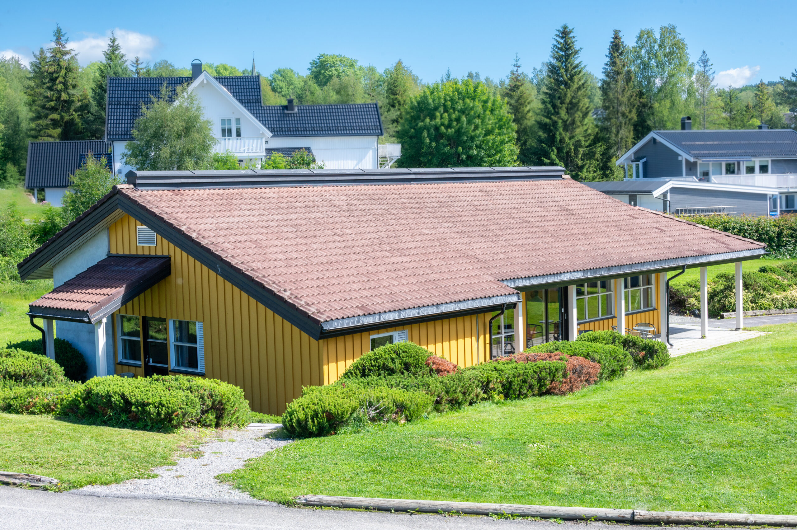 Bygget Ragnhild Kaata sett fra administrasjonsbygget. Et lavt avlangt hus med vinduer på langsiden og gress utenfor.